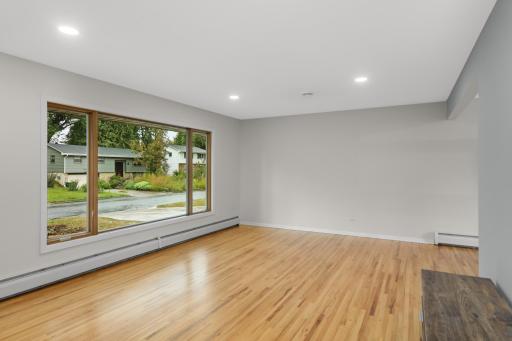 Main level living room with huge picture window & hardwood floors