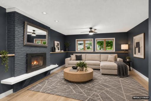 Gas fireplace with brick surround & ceiling fan (virtually staged)