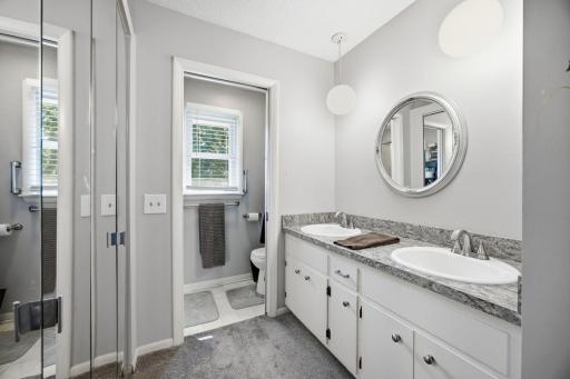 Private primary ensuite with double sinks, a private toilet & walk-in shower, and walk-in closets.
