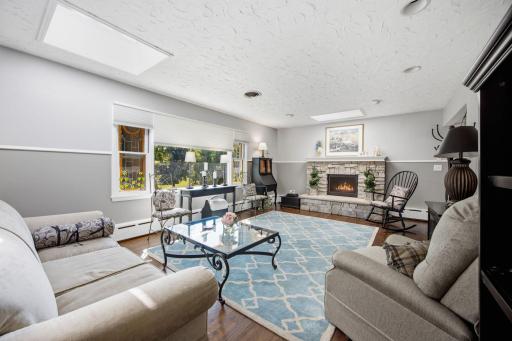 The spacious main level living room offers beautiful hardwood floors, stain glassed and picture windows, and a gorgeous stone-wrapped wood burning fire place.