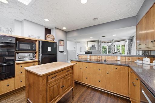 The kitchen has a floating center island, breakfast bar, and opens to the dining room.