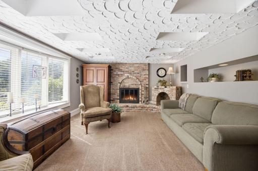 The lower level family area provides a gorgeous brick surround wood-burning fireplace and.
