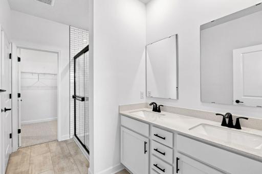 Dual sinks and direct access to the walk-in closet promotes streamlined morning and nighttime routines