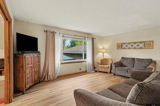 Main floor living room with large window overlooking backyard