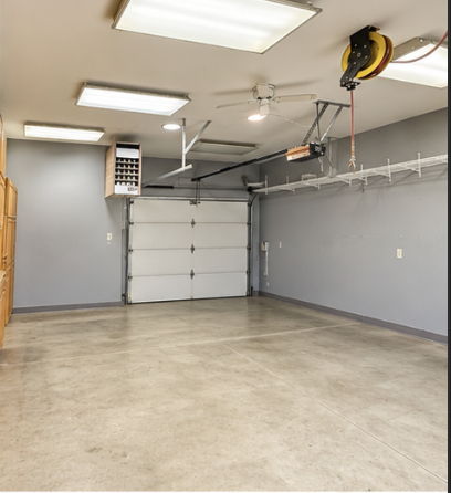 Back garage with heater, garage door to the backyard, cabinets, and air power connections/accessories