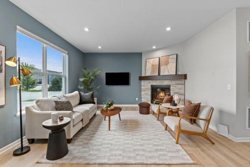 Another view of the inviting living room showcasing the fireplace, large windows, and generous layout. Plenty of room for comfortable everyday living and entertaining.