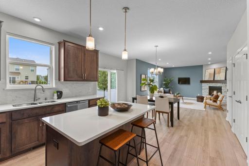 The open-concept main level seamlessly connects the living room, dining area, and kitchen. Large windows and recessed lighting keep the entire space feeling bright and open.