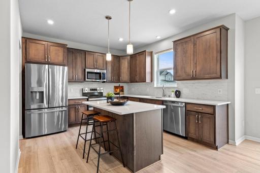 Beautiful kitchen featuring a large center island, abundant cabinetry, stainless steel appliances, and generous counter space. Island seating provides the perfect spot for casual meals or entertaining.
