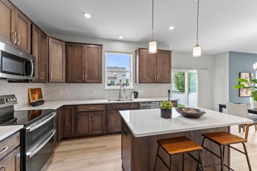 Another great view of the kitchen showcasing the generous cabinet and countertop space, stainless steel appliances, and window above the sink bringing in plenty of natural light.