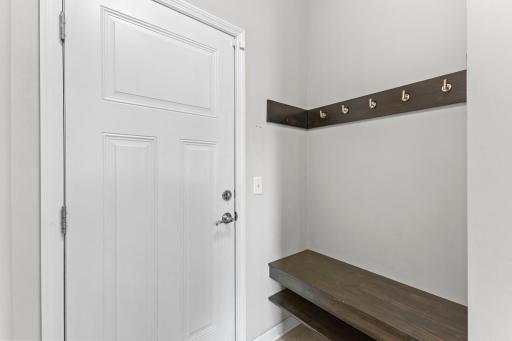 A convenient drop zone just inside the entry offers a built-in bench, storage shelf, and plenty of hooks for coats, backpacks, and everyday essentials.