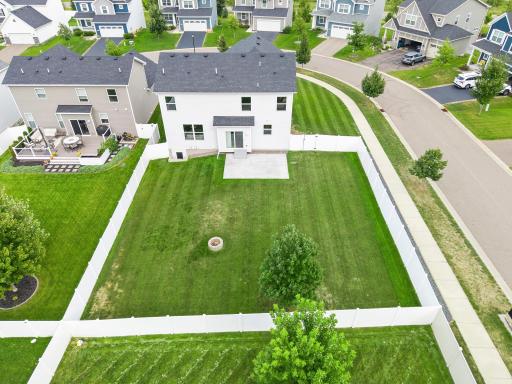The aerial view really shows off the size of this fully fenced lot. With a large lawn, patio, fire pit, and plenty of open space, this backyard is a standout feature of the home.