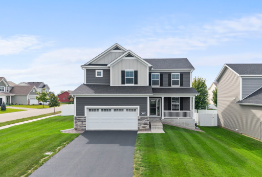 Beautiful curb appeal with a welcoming front porch, stone accents, and modern exterior finishes. A spacious oversized two-car garage and well-maintained yard complete the look.