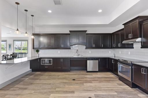 Community kitchen features abundant cabinetry, expansive counter space, stainless steel appliances, and a pass-through to the gathering roomâperfect for resident events and entertaining.
