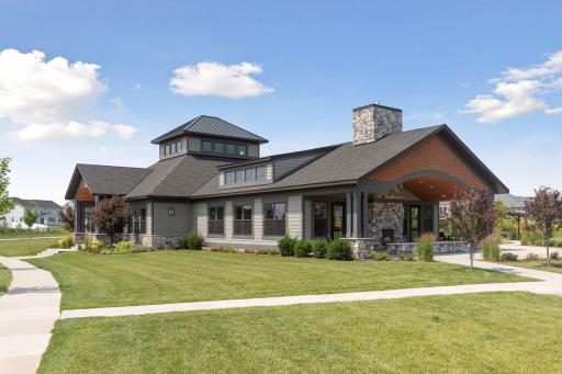 The beautifully designed community building welcomes you with impressive architecture, stone accents, mature landscaping, and an inviting covered entrance.