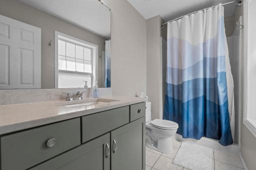 Walk-in shower, tile flooring, and generous vanity storage.