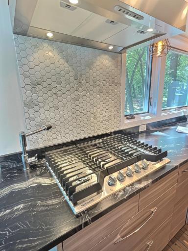 A closer look st this fantastic 5 burner gas cooktop with pot filler and high-powered hood vet.