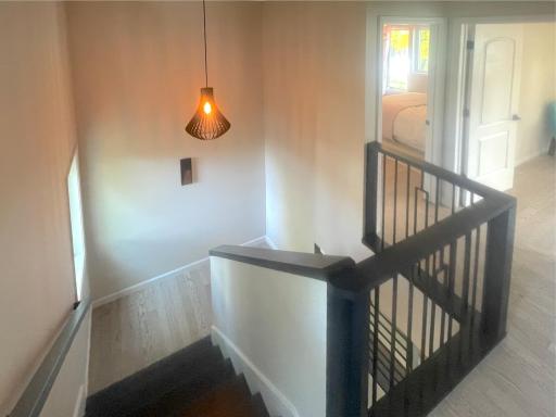 Staircase to the second floor with black metal railings and unique lighting.