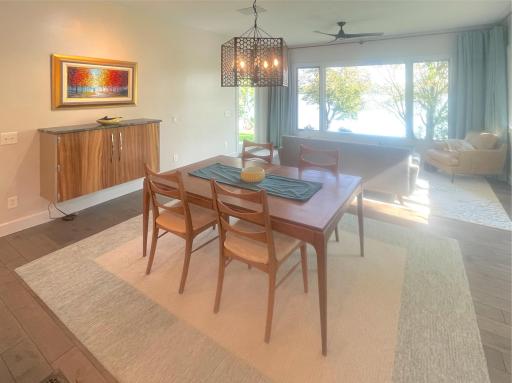 The dining area features an attached wall cabinet and wine racks, while spotlights on both sides of the room highlight special artwork.