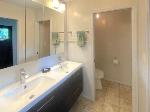 Full bathroom with double sinks and pocket doors for extra privacy.