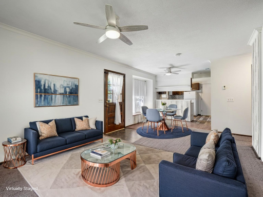 Here is the virtually staged Living/Dining rooms showing the door that leads to the deck and a path to the heated inground pool.