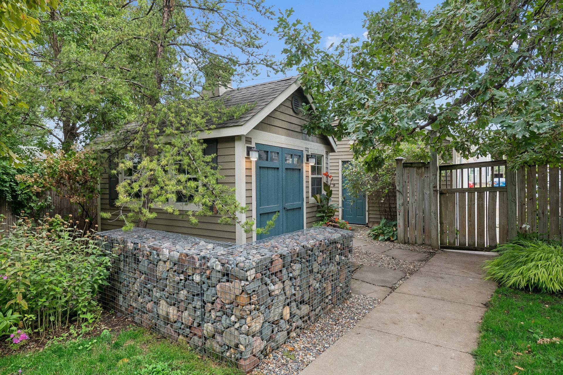 A gabion design element at the corner of the custom built garden shed.