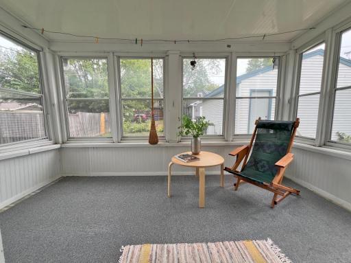 Back porch surrounded by windows, with yard & 2 car garage behind