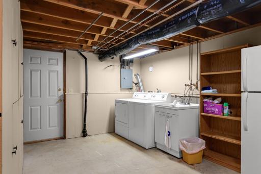 Large laundry and utility area with extra shelving and room for storage.