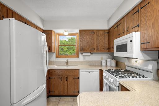 A second view of the Kitchen highlights the workspace, gas range and window above the sink.