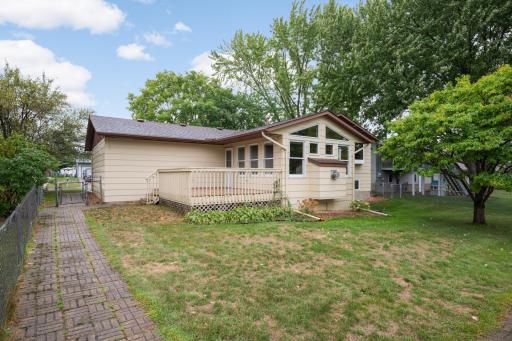 Deck off the home overlooks the fenced yard, with mature trees providing a comfortable backyard setting.