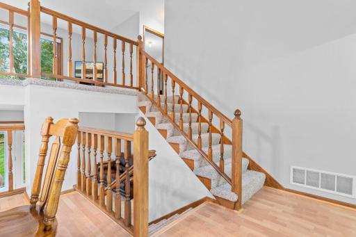 Warm and welcoming floor plan with towering vaulted ceilings and open staircase banisters.