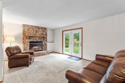The lower level is highlighted by a cozy stone wood-burning fireplace, flexible living space, and direct walkout to the backyard.