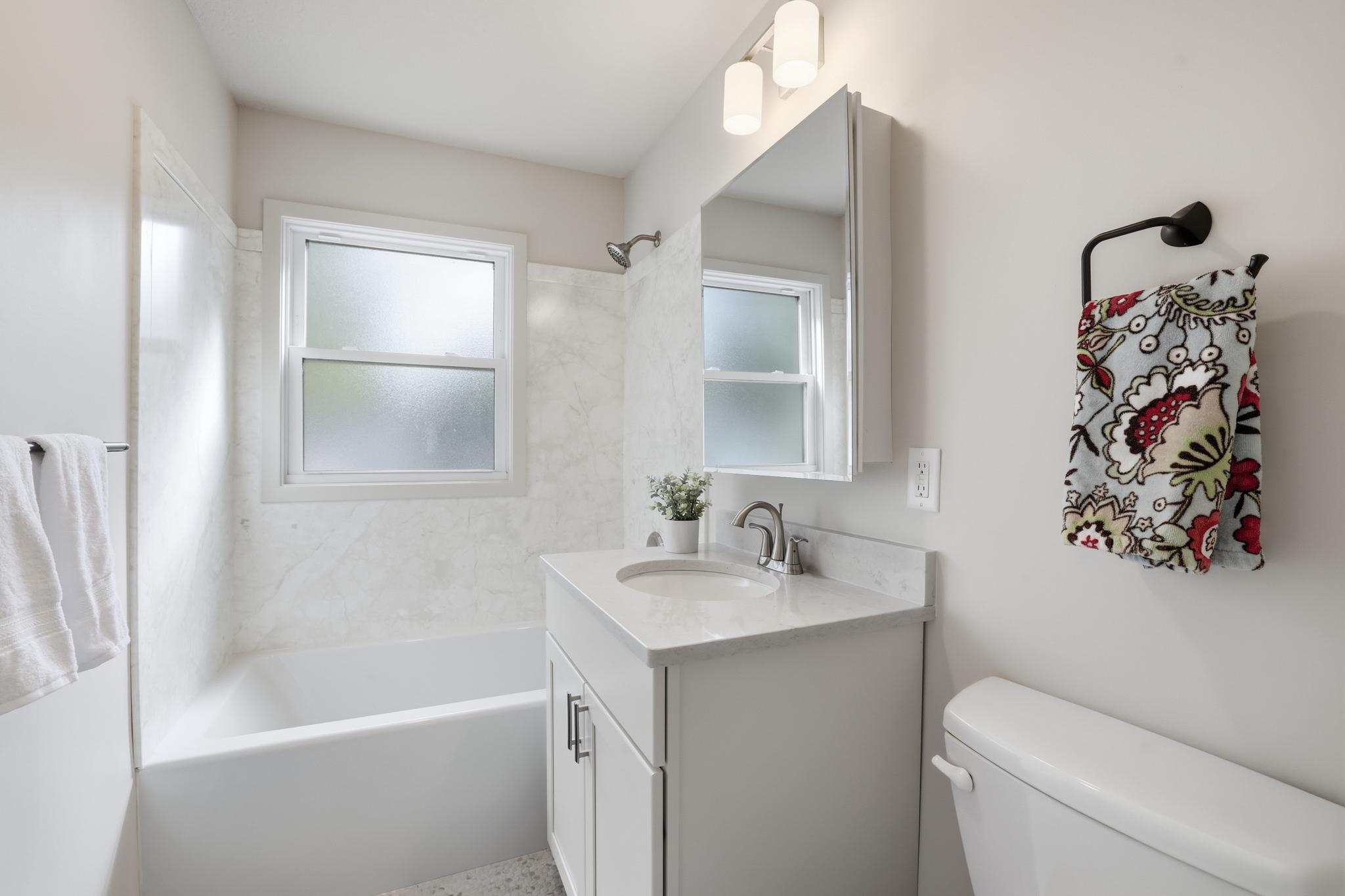 BRAND NEW full bathroom with penny floor tile, stone countertops and nice shower surround