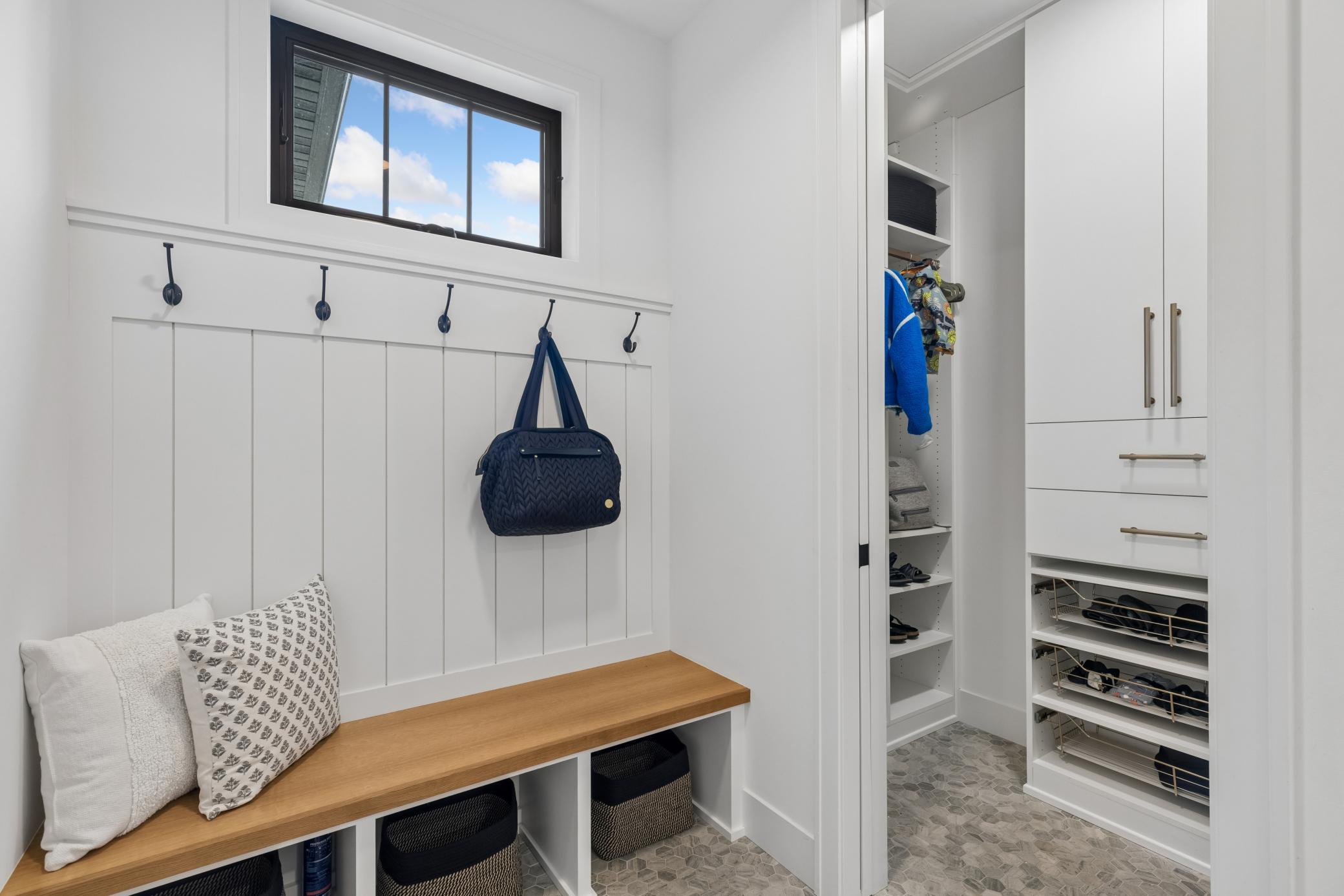 Well-designed mudroom with built-in bench, storage & California Closets pantry.