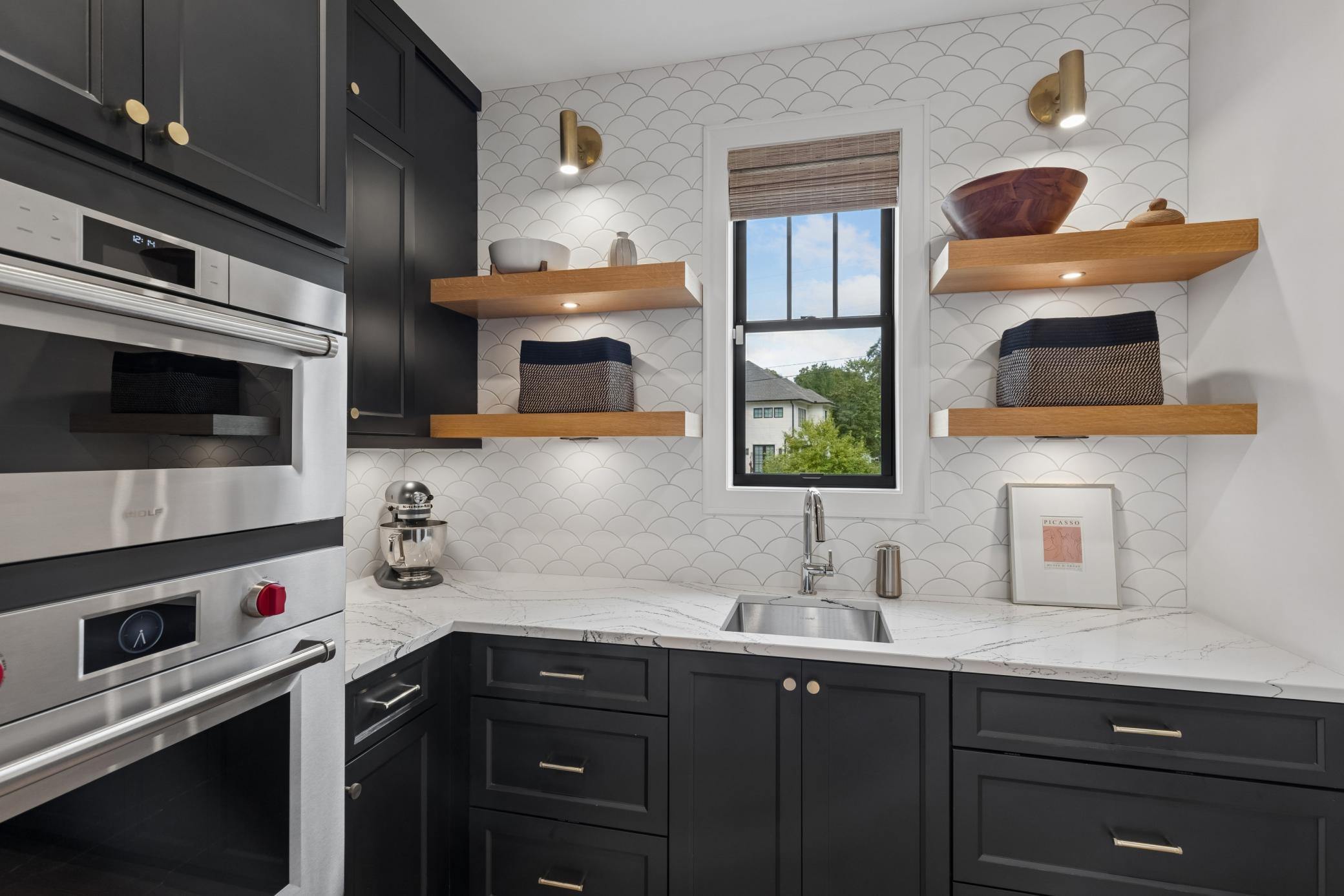 Well-appointed prep kitchen with Wolf double wall ovens & open shelvings.