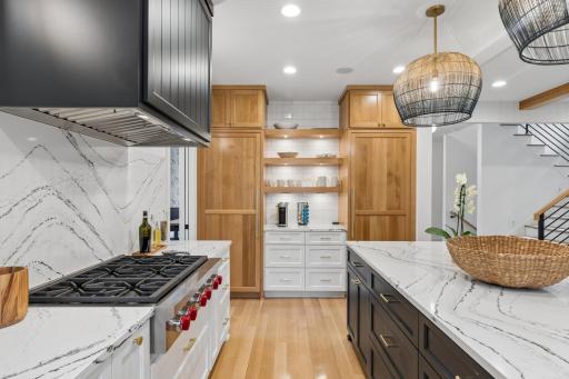 Separate paneled Sub-Zero refrigerator and freezer flank a dedicated beverage station.