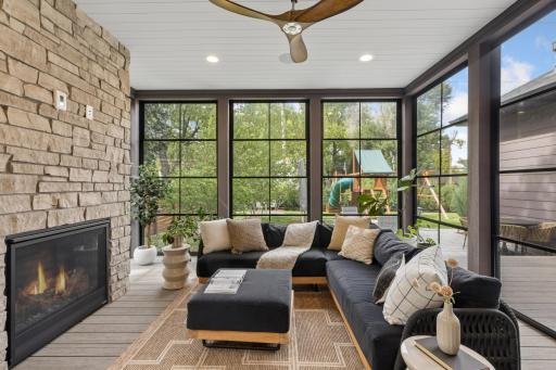 Relaxing screened porch with stone fireplace.