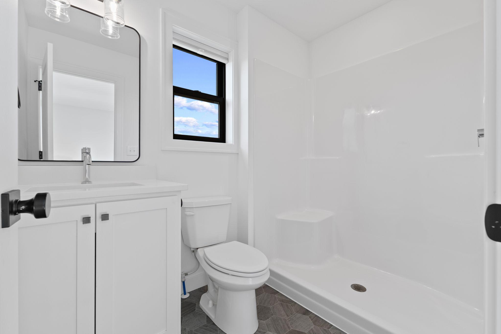 A private bathroom with a walk-in shower completes this upper-level bedroom suite.