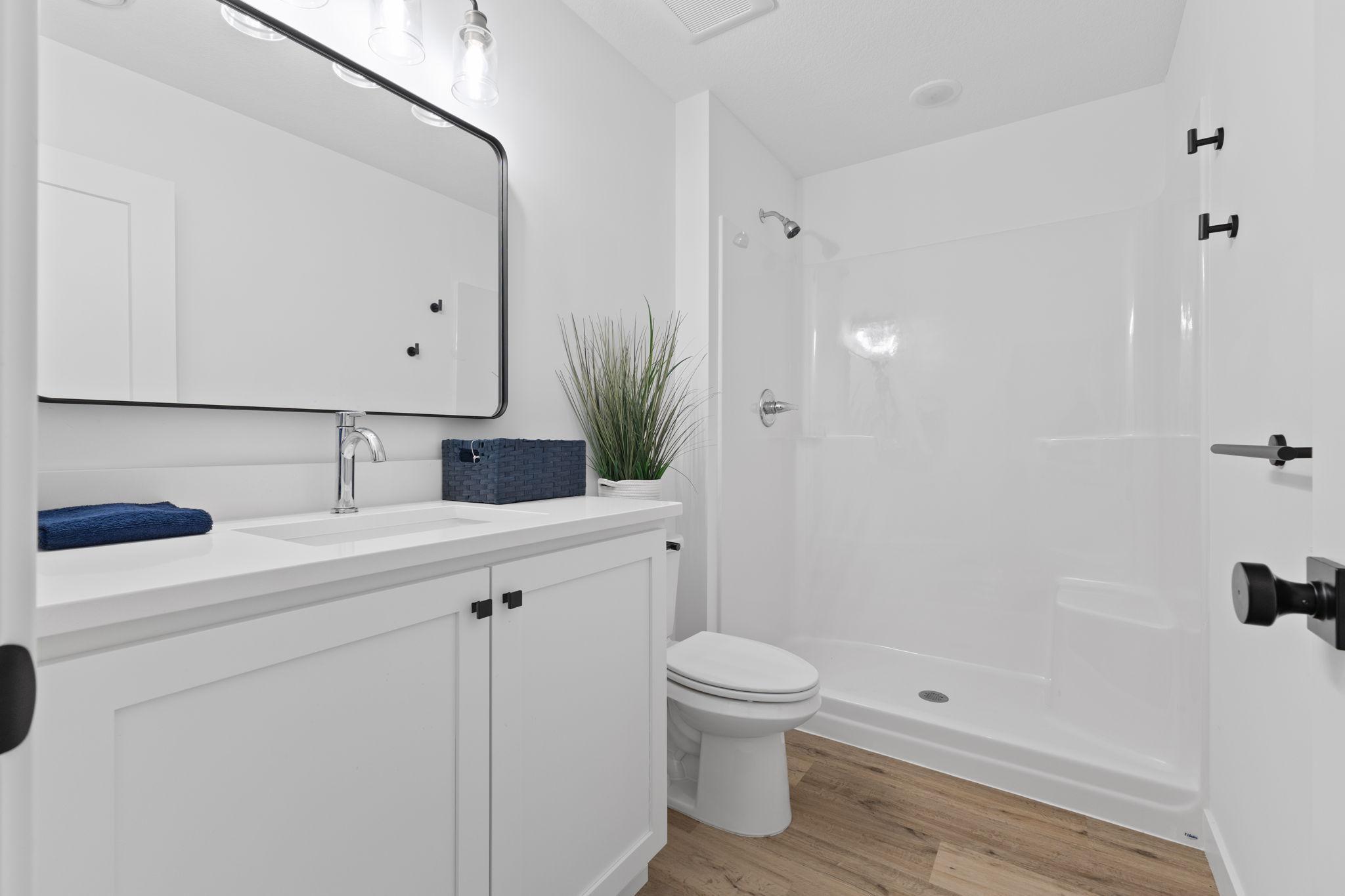 A lower-level bathroom conveniently serves the bedroom and recreation spaces.