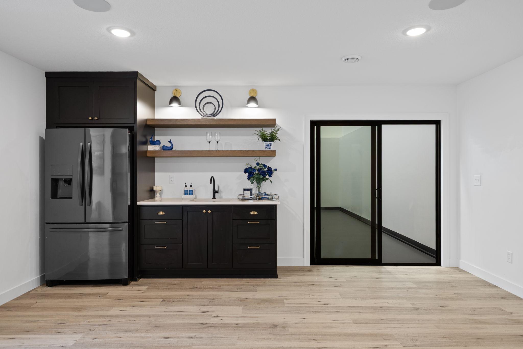 The wet bar features custom cabinetry, floating shelves and a full-size refrigerator for easy entertaining.