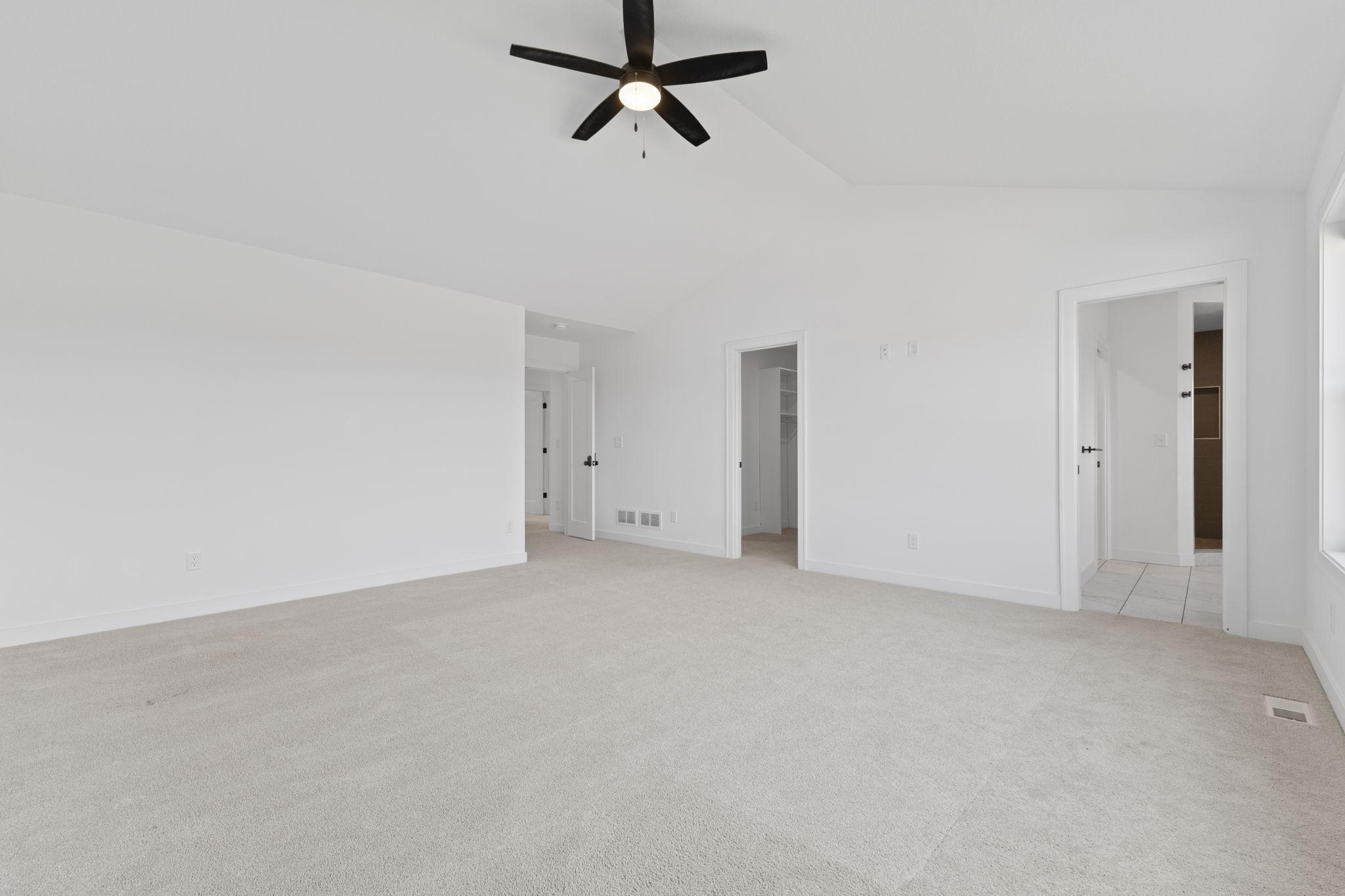 Another angle highlights the impressive size and vaulted ceiling of the primary bedroom.