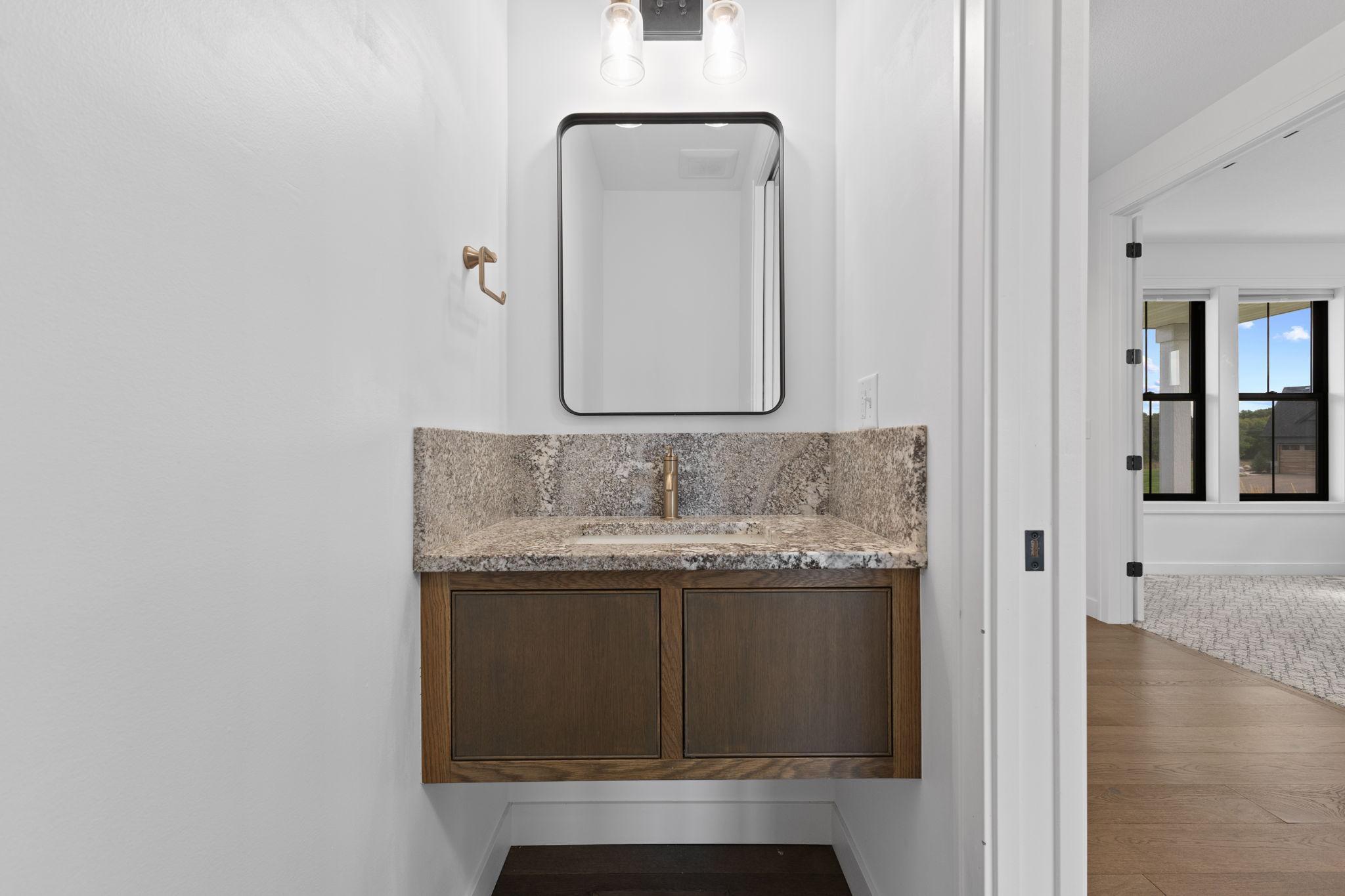 The main-level half bath features a custom built-in vanity.