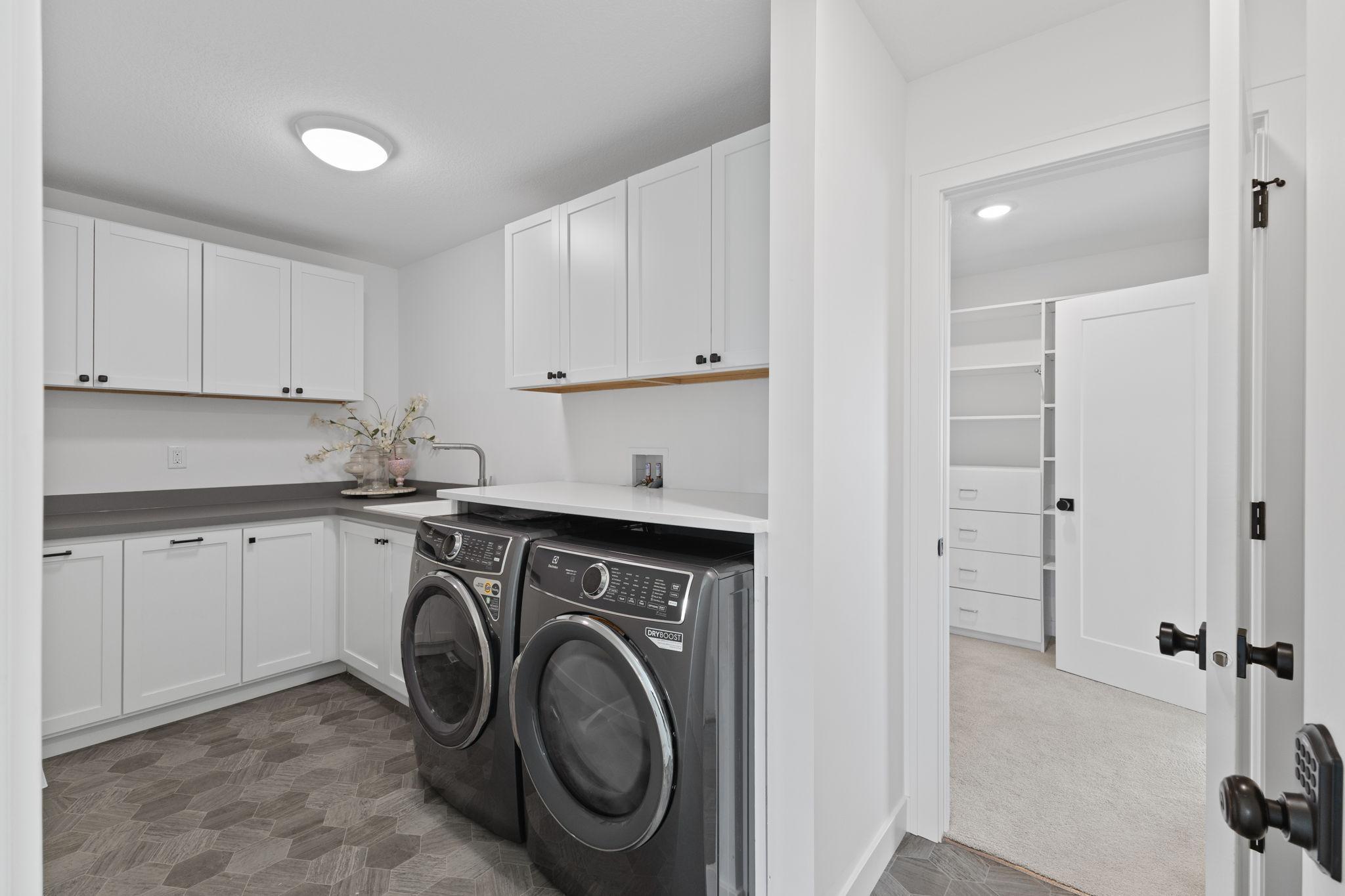 Convenient upper-level laundry features cabinetry, countertop space and room to keep everything organized.
