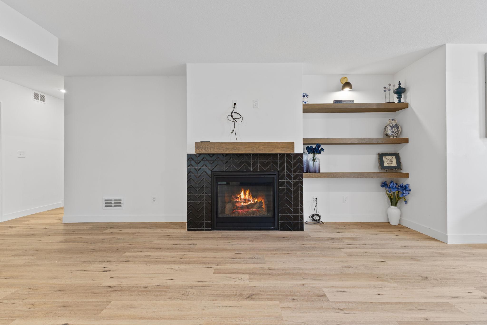 A second fireplace with custom shelving creates a cozy focal point downstairs.