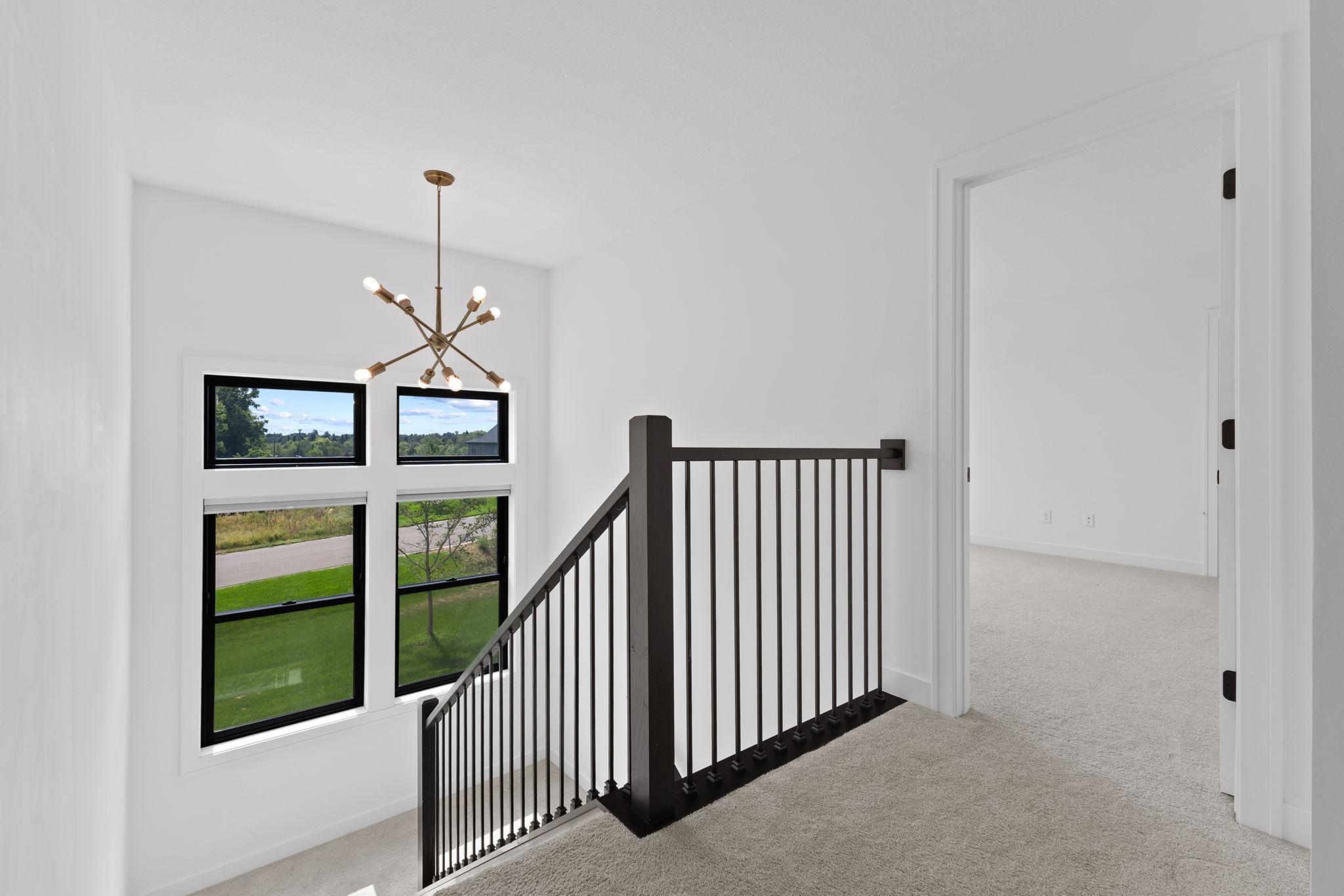 Head upstairs where modern railings, large windows and a statement light fixture continue the home's stylish design.