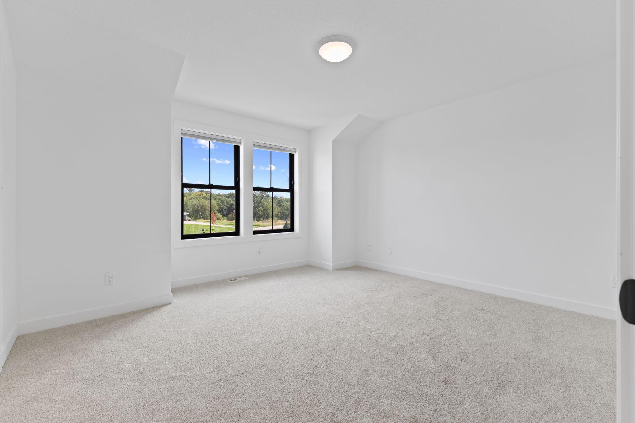 A spacious secondary bedroom with neutral finishes and great natural light.