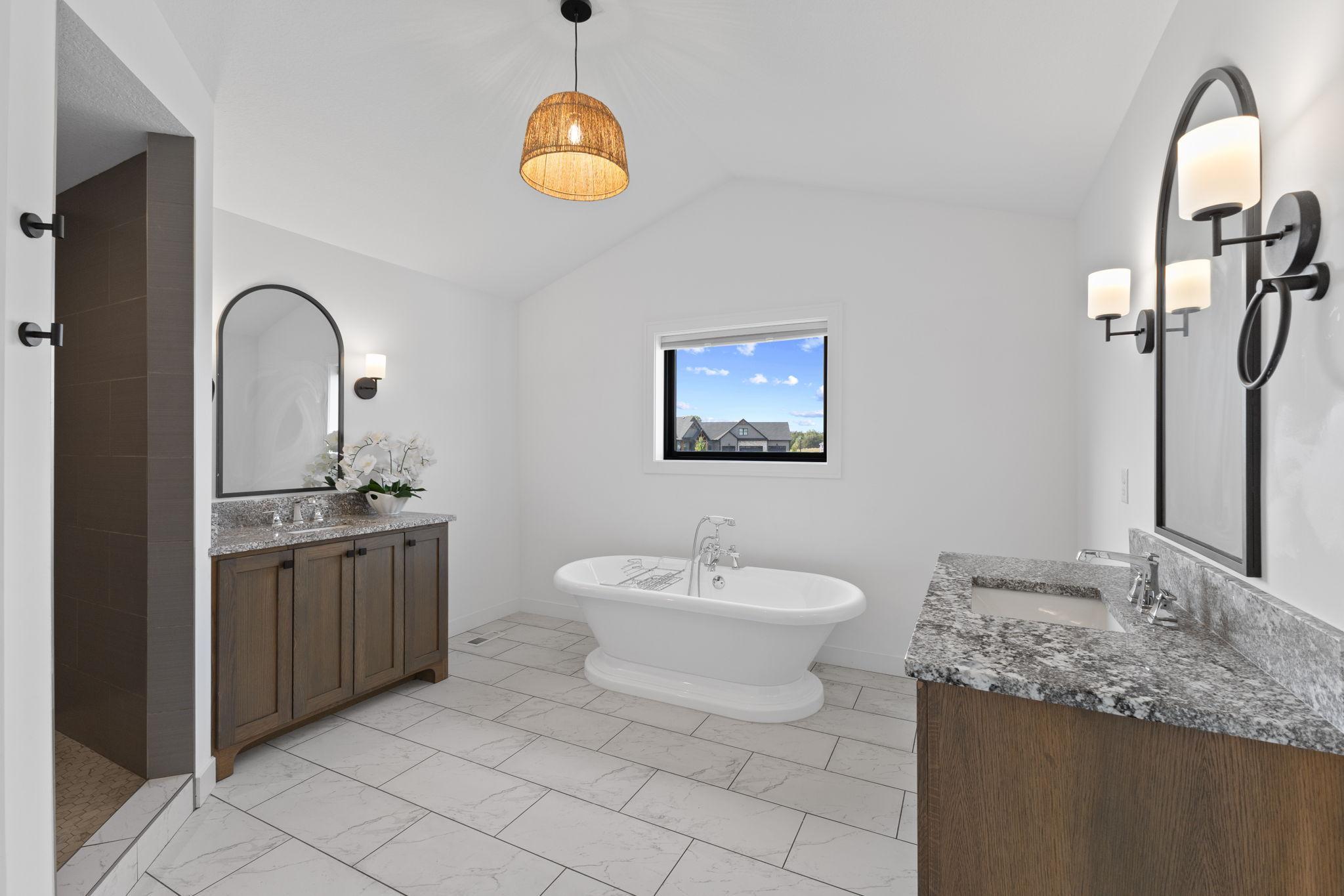 The spa-like primary bath features dual vanities and a freestanding soaking tub.