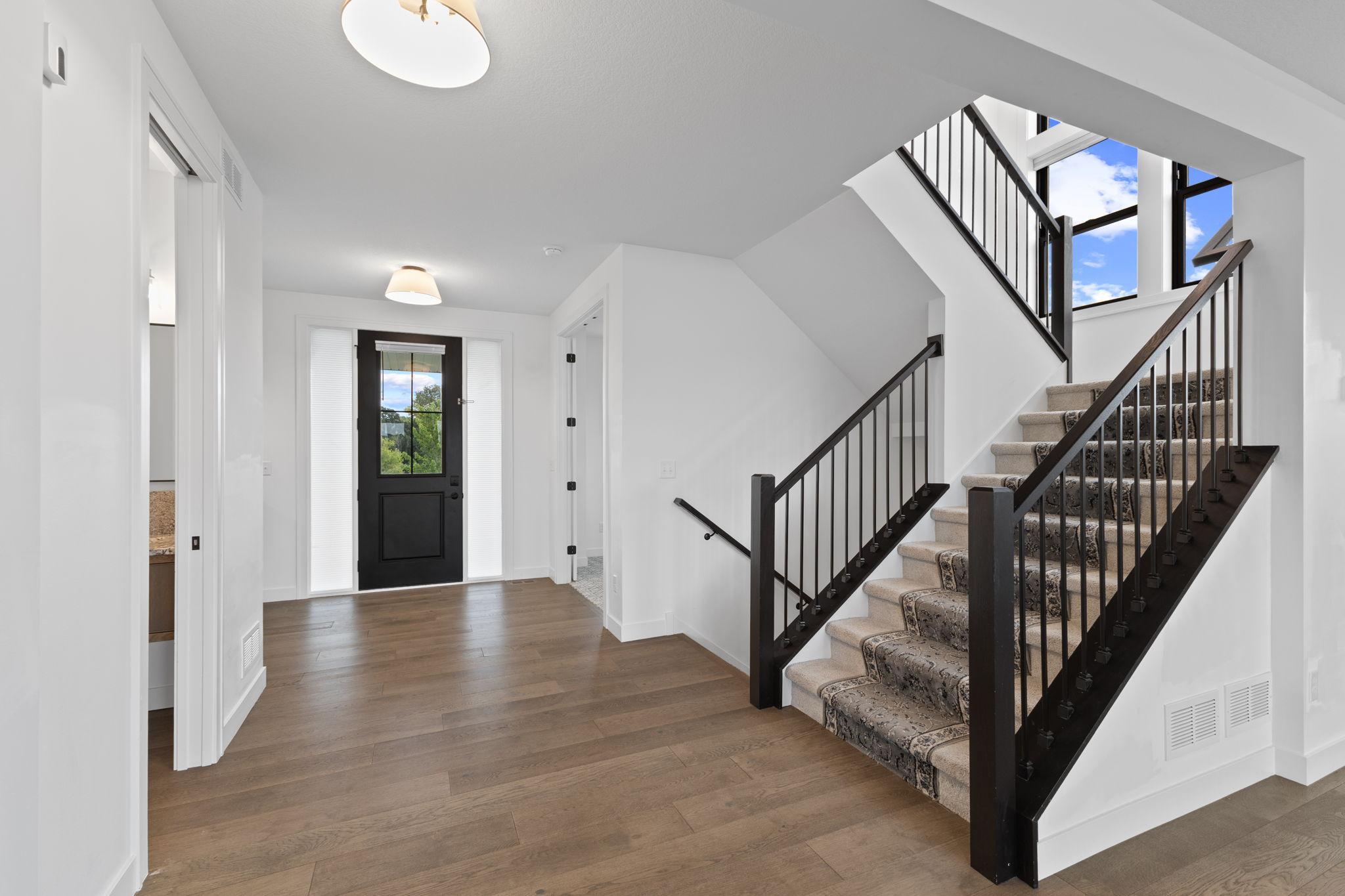 Modern black railings provide a striking contrast and complement the home's clean, custom design.