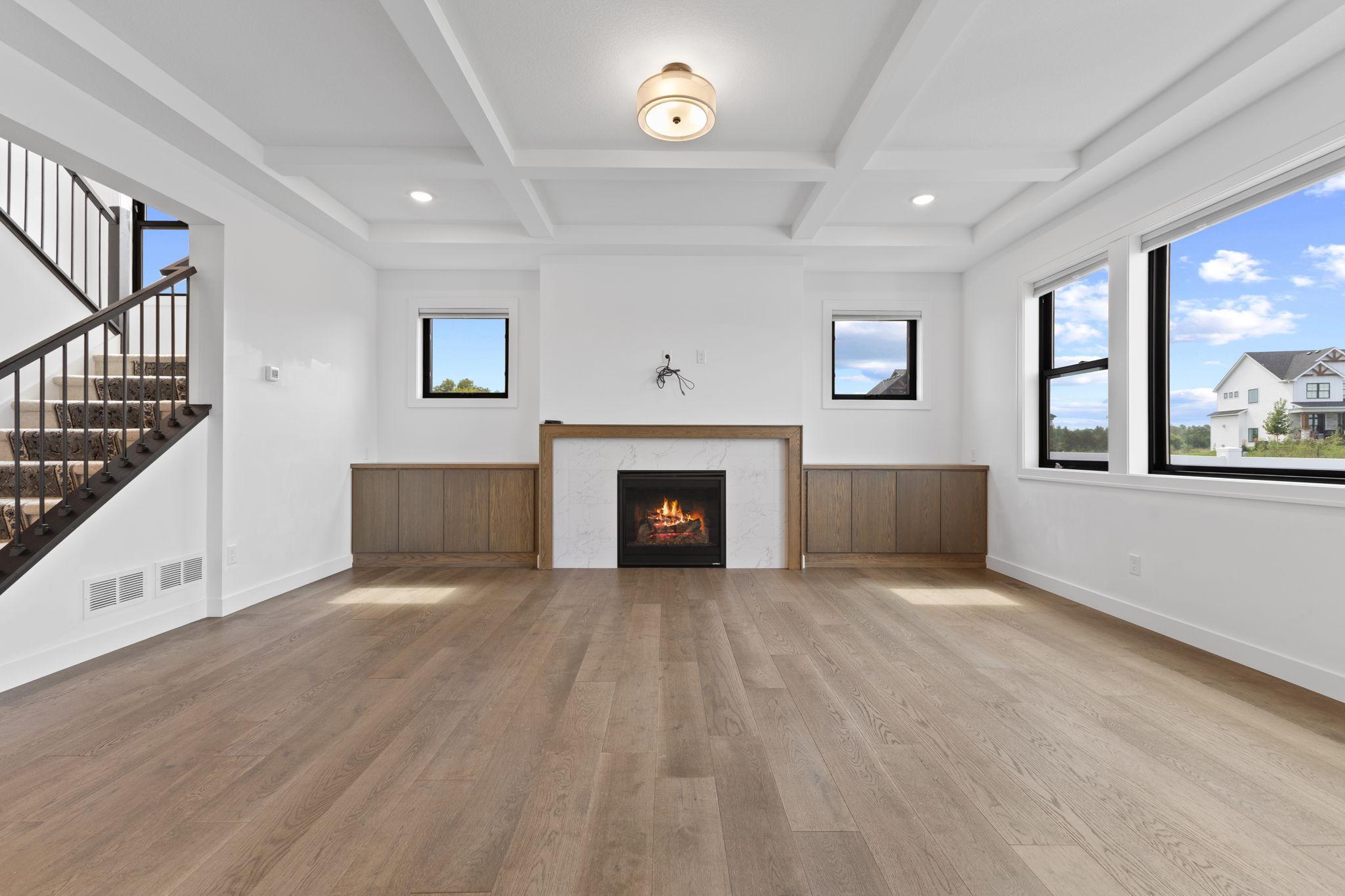 A striking fireplace creates a warm focal point framed by custom wood detailing.