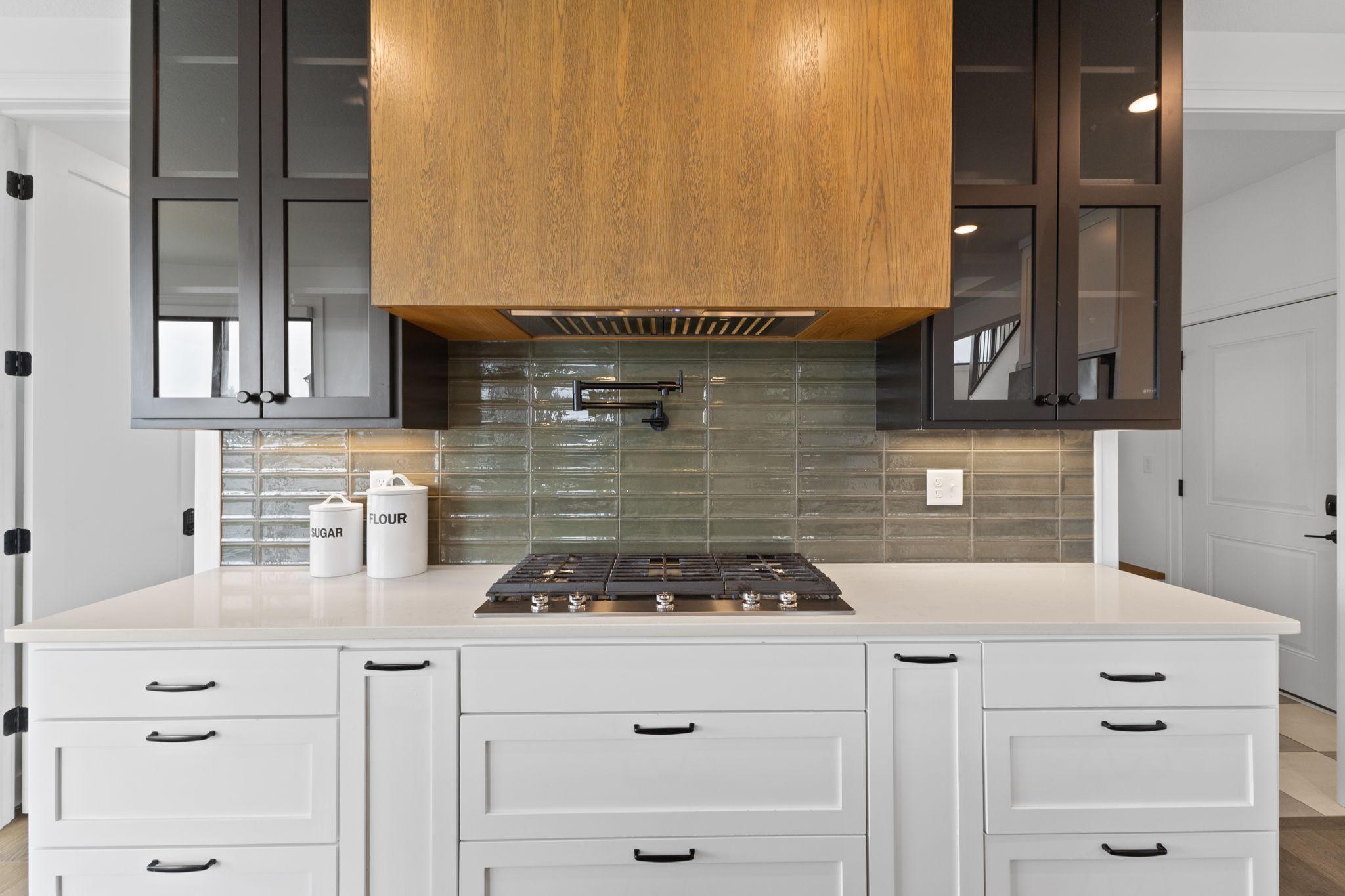 A pot filler and statement range hood add function and a custom touch to the cooking area.