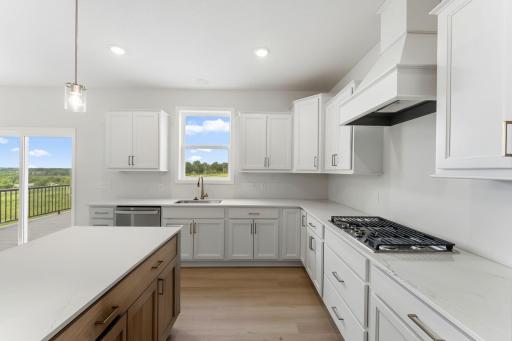 For representational purposes only. Look at all the counter top, storage space and natural light the kitchen provides! The sink location is ideal as well, not taking up island space where guests like to gather. (model photo)